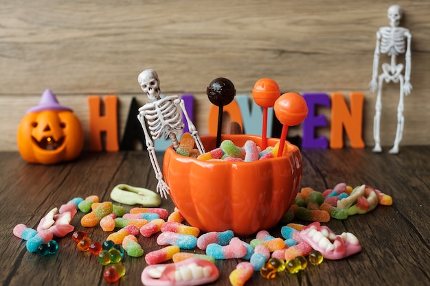 Foto feliz día de halloween con caramelos fantasma, cuenco de calabaza, linterna jack o y decoración (enfoque selectivo). truco o amenaza, hola octubre, otoño otoño, concepto festivo, fiesta y vacaciones