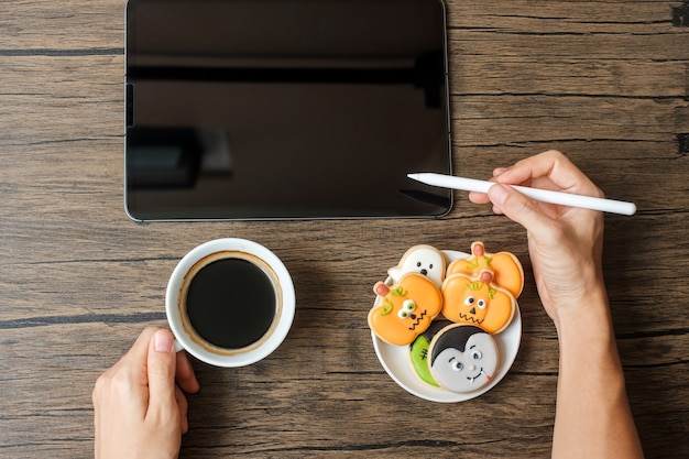 Feliz día de Halloween con galletas, café y tableta. compras en línea, hola octubre, otoño otoño, concepto festivo, fiesta y vacaciones