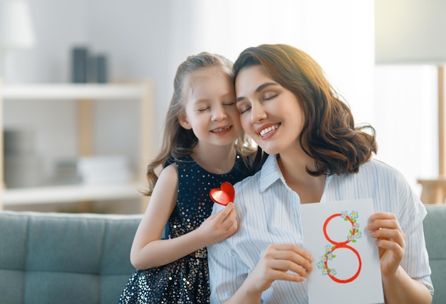 Feliz dia internacional da mulher filha filha está parabenizando a mãe e dando seu cartão postal