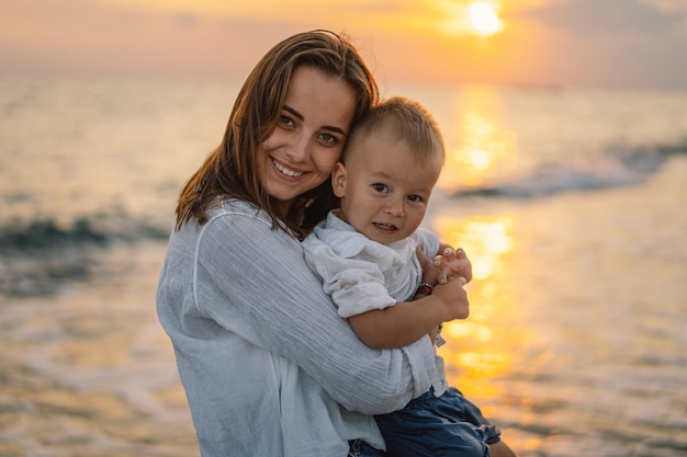 Feliz día de la madre Hermosa madre y bebé juegan en la playa