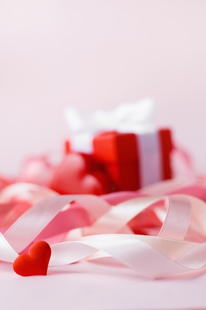 Feliz Día de la Madre o Día de San Valentín Pequeño corazón rojo en el fondo de cintas navideñas borrosas