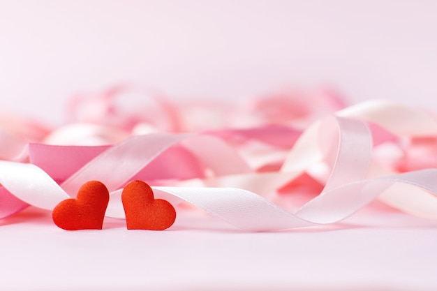 Feliz Día de la Madre Pequeños corazones rojos en el fondo de cintas de vacaciones borrosas sobre fondo rosa