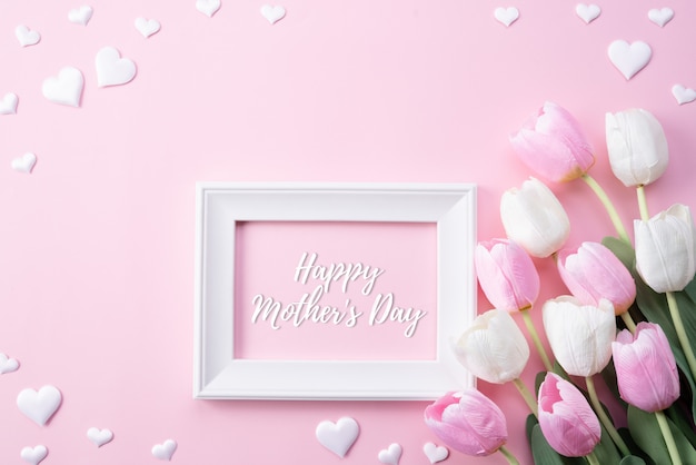 Feliz día de las madres con vista superior de flores de tulipán rosa y marco blanco