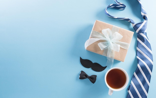 Foto feliz día del padre concepto de fondo con caja de regalo decorada pajarita corbata y bigote sobre fondo pastel brillante