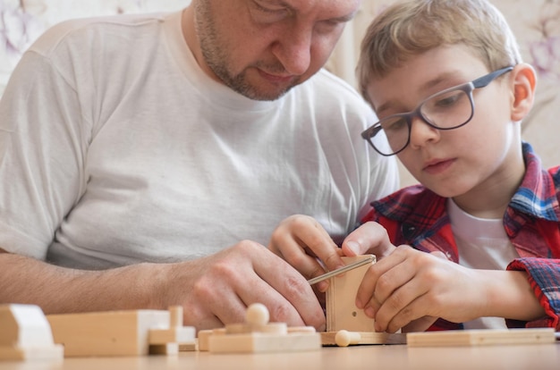 Feliz día del padre y concepto de infancia Padre e hijo con anteojos trabajan con herramientas manuales usando