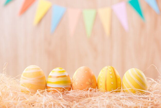 Feliz día de Pascua coloridos huevos en el nido con borrosa celebrar banderas de fiesta con espacio de copia