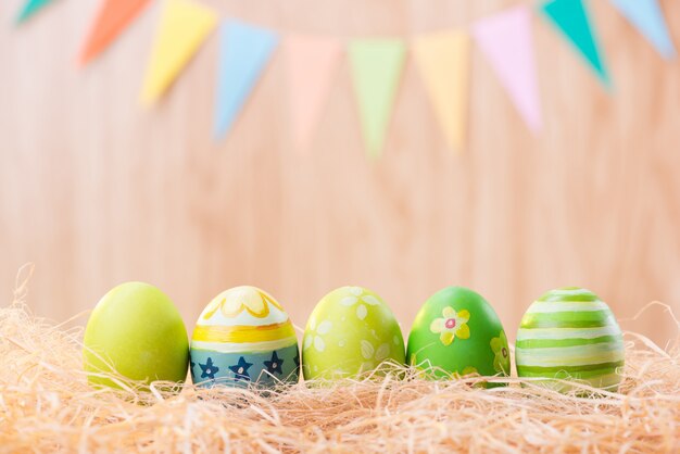 Feliz día de Pascua coloridos huevos en el nido con borrosa celebrar banderas de fiesta con espacio de copia