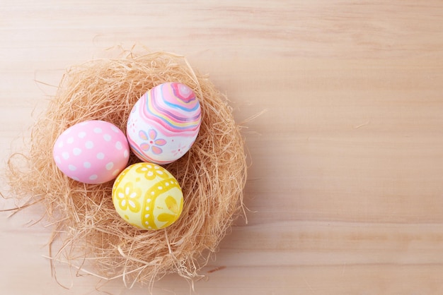 Feliz día de Pascua huevos en nido sobre fondo de madera con espacio de copia