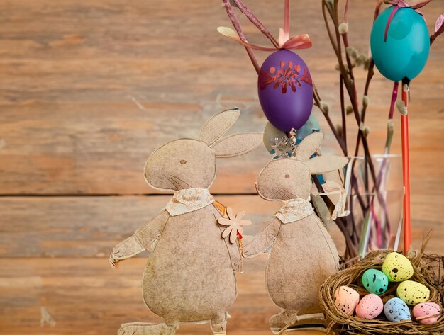 Foto feliz día de pascua huevos de pascua y conejitos de pascua en fondo de madera