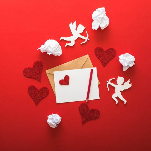 Feliz día de San Valentín saludo tipografía con elementos de San Valentín de carta, regalos, corazones sobre fondo de papel rojo.