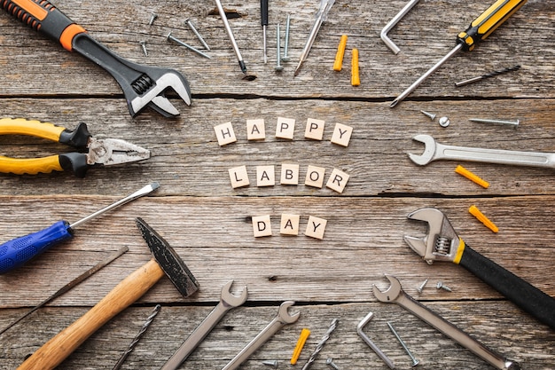 Feliz día del trabajo en bloques de madera y herramientas de construcción en la vista superior de fondo de madera