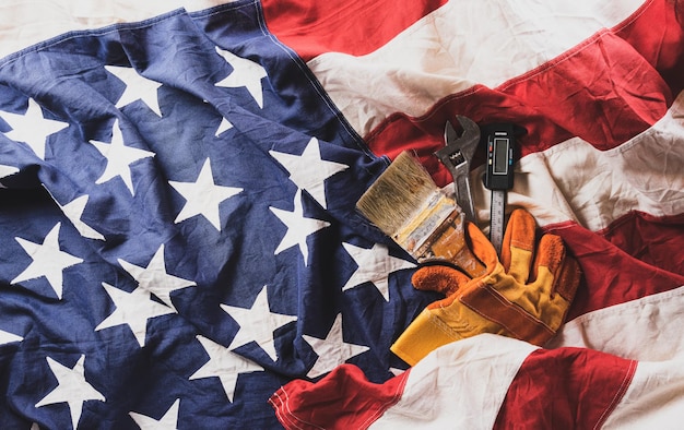 Feliz Día del Trabajo concepto bandera estadounidense con diferentes herramientas de construcción sobre fondo de madera oscura