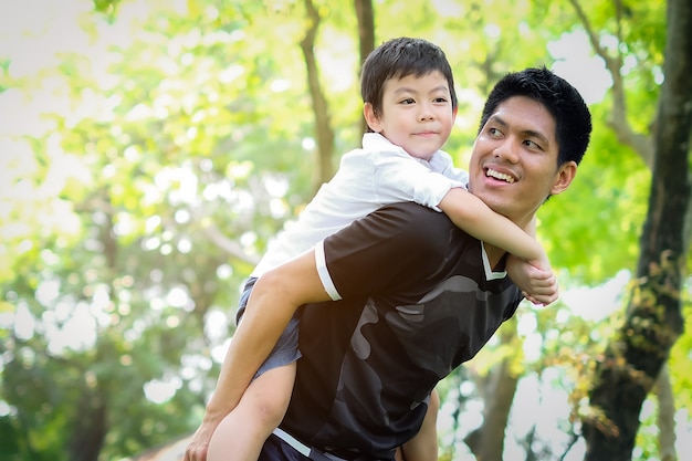 Feliz y disfrutar de padre e hijo asiáticos divirtiéndose en el parque de verano