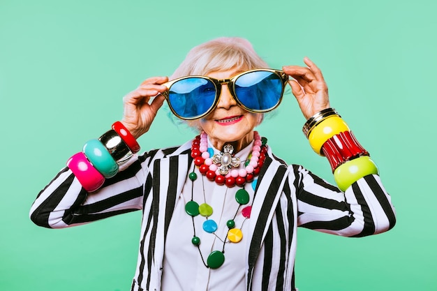 Feliz y divertida anciana fresca con retrato de ropa de moda sobre fondo de color Abuela juvenil con conceptos de estilo extravagante sobre la antigüedad del estilo de vida y las personas mayores