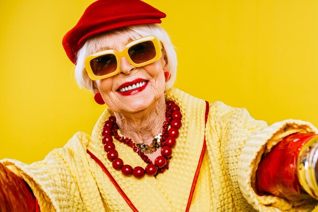 Feliz y divertida anciana fresca con retrato de ropa de moda sobre fondo de color Abuela juvenil con conceptos de estilo extravagante sobre la antigüedad del estilo de vida y las personas mayores