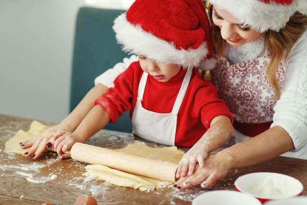 Feliz y divertida madre e hijo hornean galletas navideñas