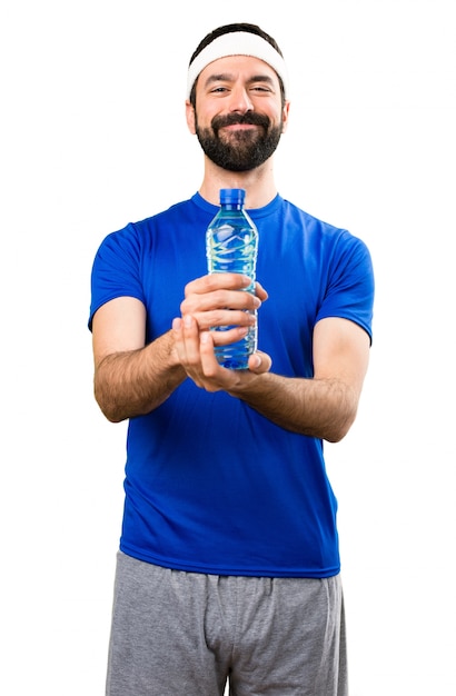 Feliz divertido deportista con una botella de agua sobre fondo blanco aislado