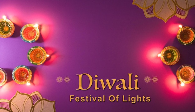 Feliz Diwali Clay Diya lámparas encendidas durante el festival hindú de luces Dipavali celebración Colorida lámpara de aceite tradicional diya sobre fondo púrpura