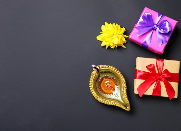 Feliz Diwali Diya lámpara de aceite flores y cajas de regalo sobre fondo rojo Celebrando el tradicional festival indio de la luz