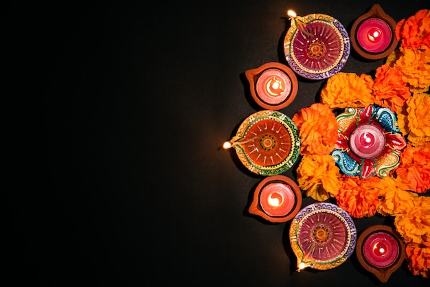 Feliz Diwali-festival hindú, colorida lámpara de aceite tradicional diya en negro