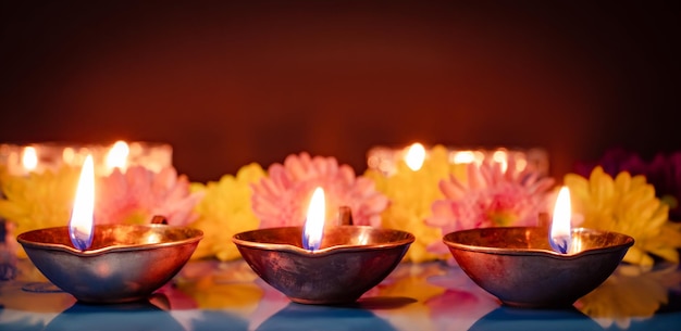 Feliz Diwali Símbolos tradicionales del festival indio de la luz Quema de lámparas de aceite diya y flores sobre fondo rojo