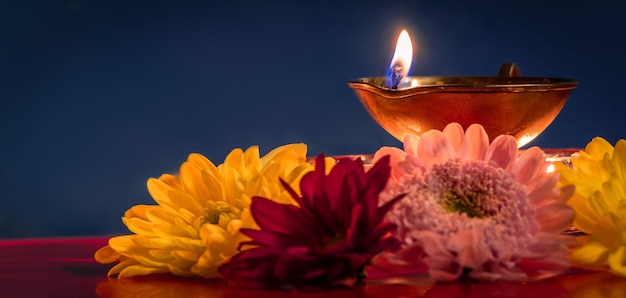 Feliz Diwali tradicional festival indiano de luz Queimando lâmpadas de óleo diya e flores em fundo vermelho