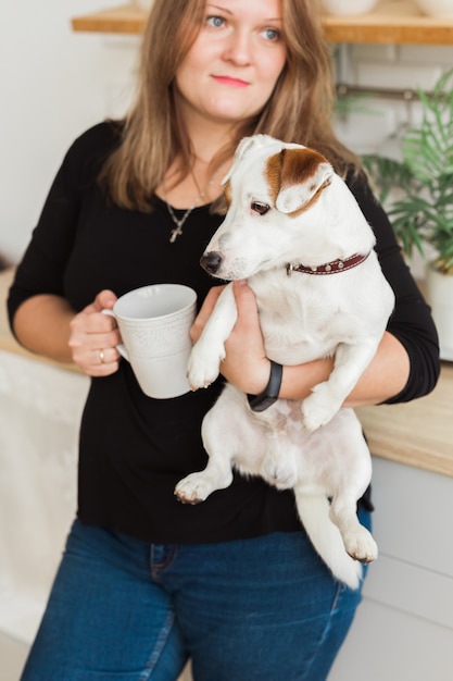 Feliz dueña de perro jack russell terrier siente la responsabilidad de cuidar de la mascota de pie