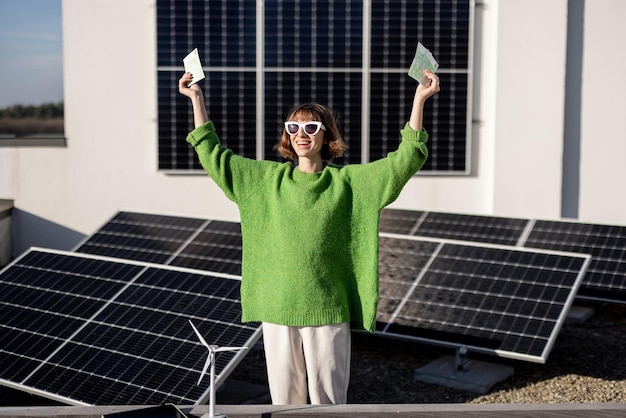 Feliz dueño de casa con dinero cerca de la planta de energía solar