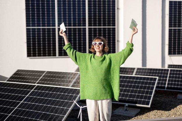 Foto feliz dueño de casa con dinero cerca de la planta de energía solar