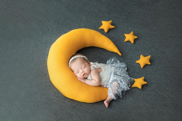 Feliz e adorável bebê recém-nascido asiático dormindo com travesseiro em forma de lua e estrela