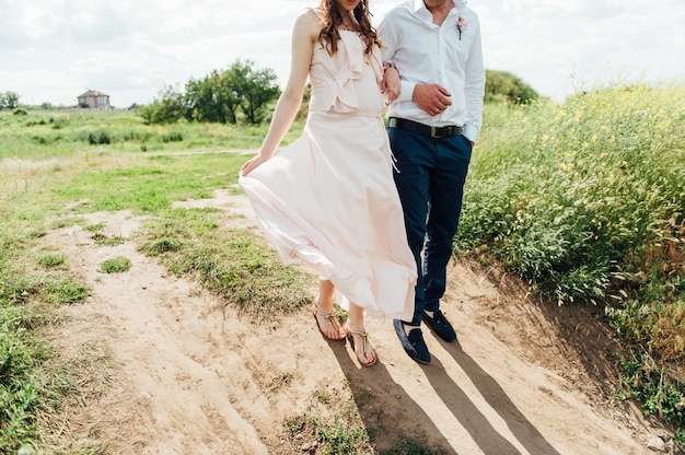 Feliz e jovem casal grávida abraçando