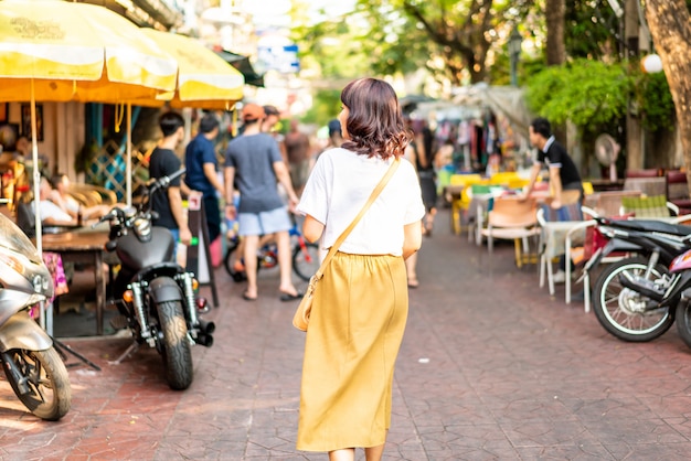 Feliz e linda mulher asiática viajando na khao sarn road, tailândia