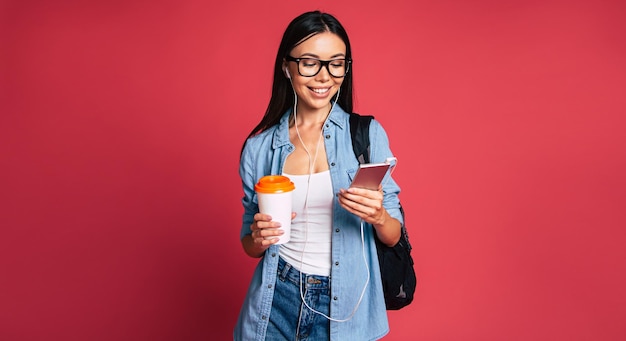 Feliz y emocionada linda joven estudiante retrato de niña en gafas con mochila aislada en el estudio