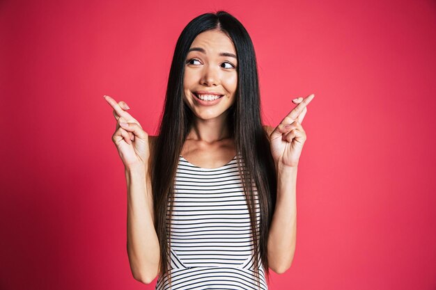 Feliz y emocionado hermoso retrato de mujer asiática joven aislado sobre fondo rosa. Concepto de emociones de personas