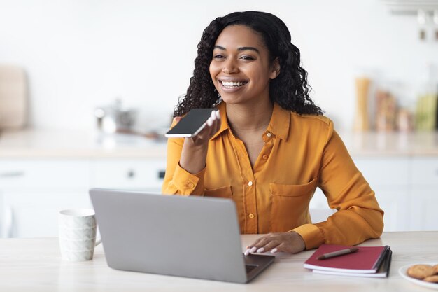 Feliz empresaria afroamericana grabando espacio de copia de mensaje de voz