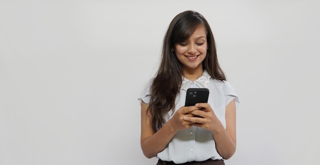 Foto feliz empresária asiática usando telefone celular isolado sobre fundo cinza