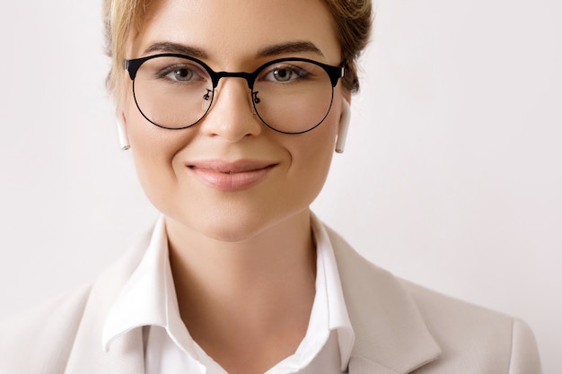 Feliz empresaria con auriculares inalámbricos en los oídos