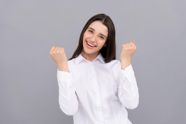 Feliz empresaria exitosa en camisa blanca sobre fondo gris, éxito.