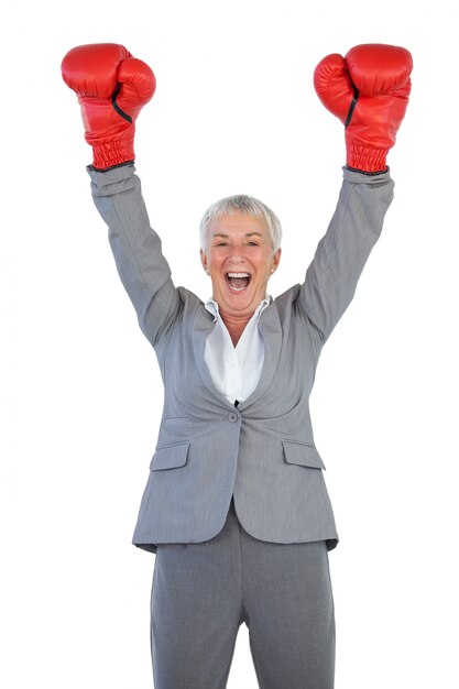 Feliz empresaria con guantes de boxeo y levantando los brazos