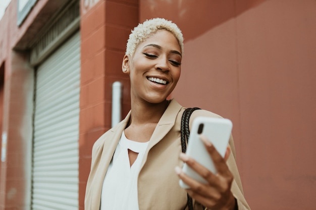 Feliz empresaria negra con su teléfono inteligente