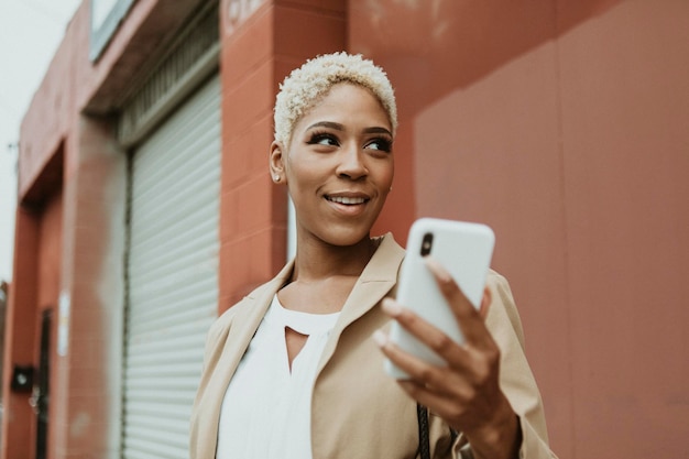 Feliz empresária negra usando seu smartphone