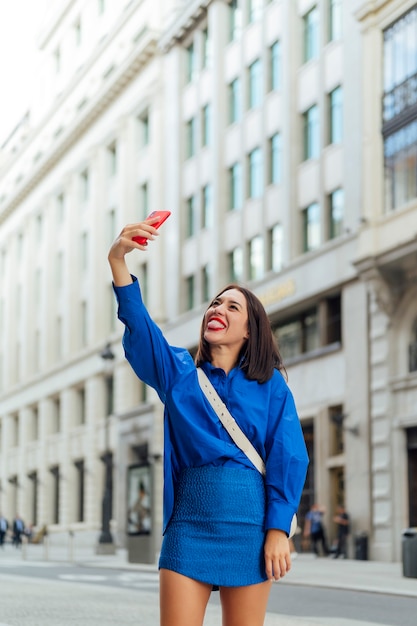 Foto feliz empresaria tomando un selfie en la calle