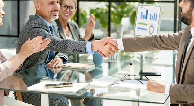 Feliz empresário apertando as mãos de seu parceiro financeiro