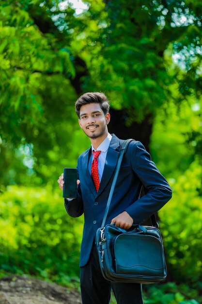 Feliz empresario dedo acusador en la pantalla del smartphone en blanco