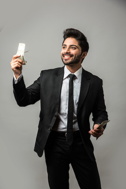 Feliz empresario indio barbudo sosteniendo el ventilador en la mano, billetes de 500 rupias indias, que se encuentran aisladas sobre fondo blanco.