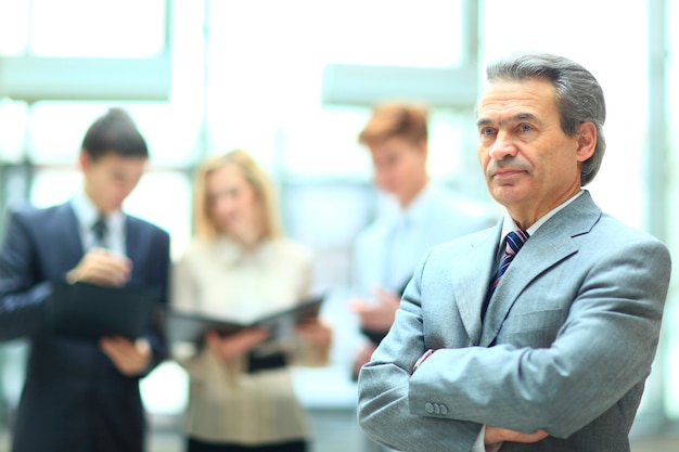 Feliz empresario inteligente con compañeros de equipo discutiendo en el fondo