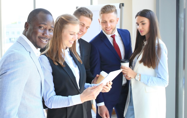 Feliz empresario inteligente con compañeros de equipo discutiendo en el fondo