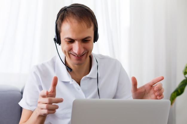 Foto feliz empresário no escritório no telefone, fone de ouvido, skype. olhando a câmera