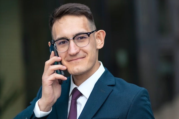 Feliz empresario positivo hablando por teléfono