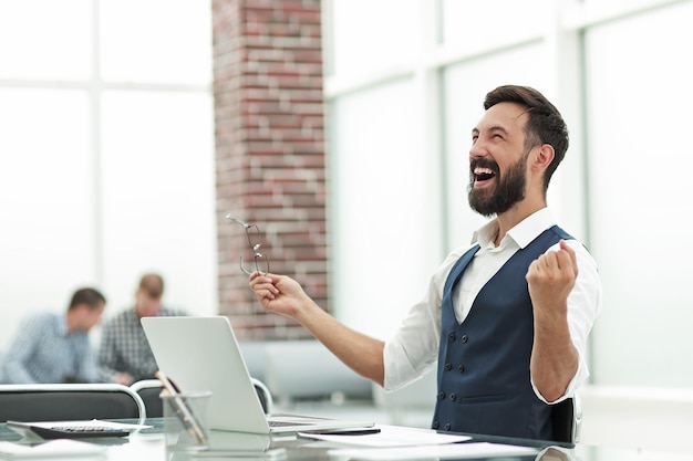 Feliz empresário sentado na mesa do escritório